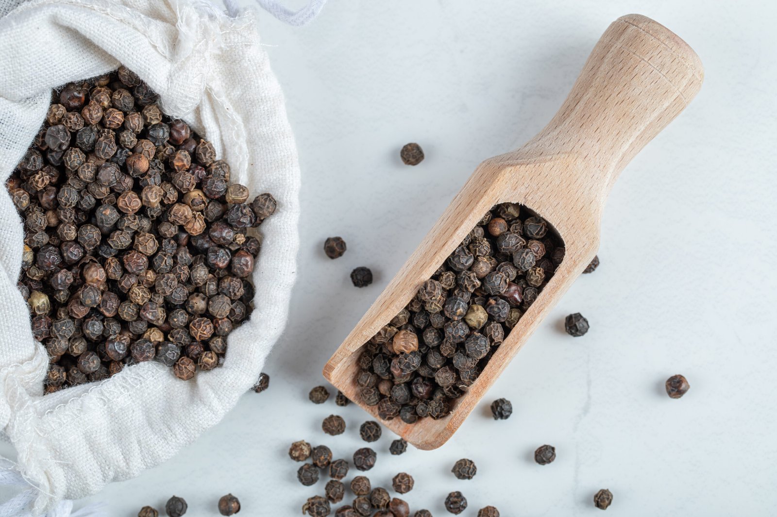A white sack full of dried pepper on a gray background. High quality photo